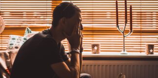 5 respostas bíblicas à sociedade do cansaço man sitting on chair covering his eyes