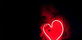 Sonde seu coração a heart shaped neon sign in the dark