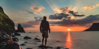 Um homem segundo o coração de Deus man standing on stone looking at sunset