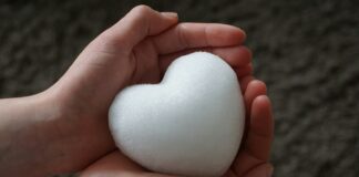 Os gemidos do coração a person holding a white heart in their hands