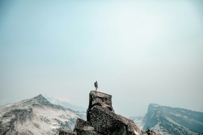 Photo by David Gavi a person standing on top of a mountain