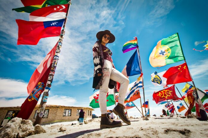 Photo by Jeison Higuita woman standing near flags