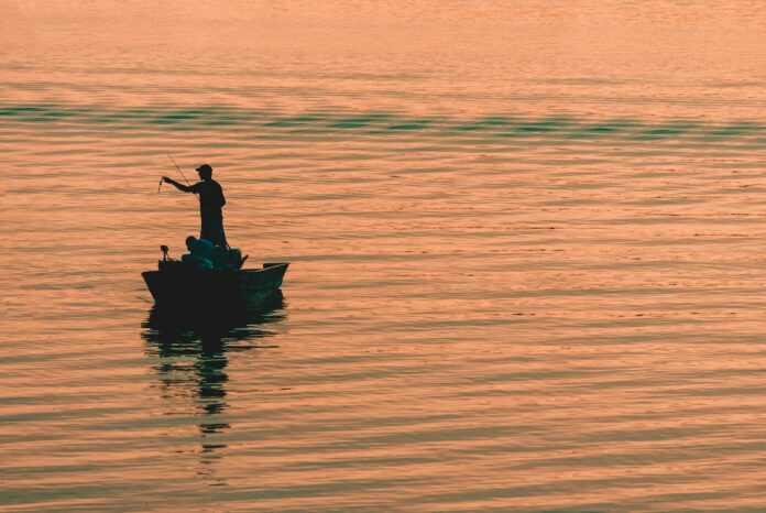 Photo by Kelly Sikkema person on boat fishing