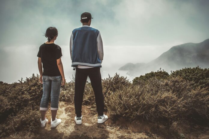 Photo by Tim Mossholder man and woman standing on mountain during day