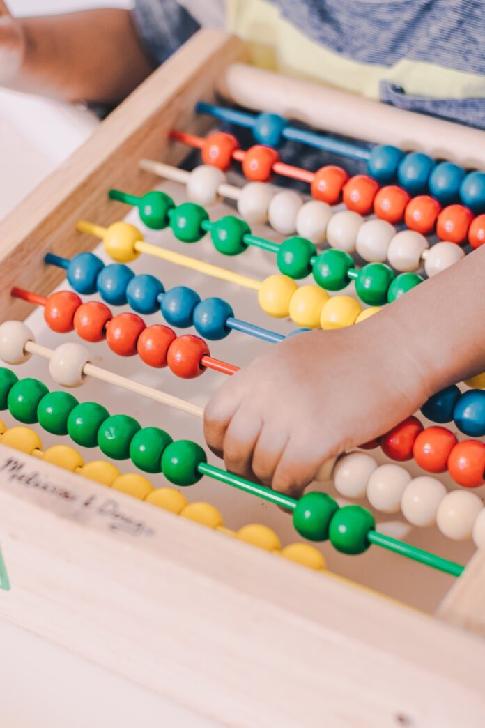 Photo by luis arias person holding red and blue abacus