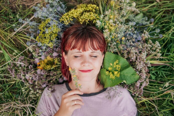 Photo by Aleksandra Sapozhnikova woman in gray crew neck shirt lying on green grass