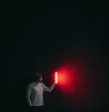 Procurando uma luz man in white shirt standing in front of red light