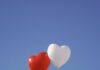 Deixe seu coração guiar two heart shaped balloons floating in the air