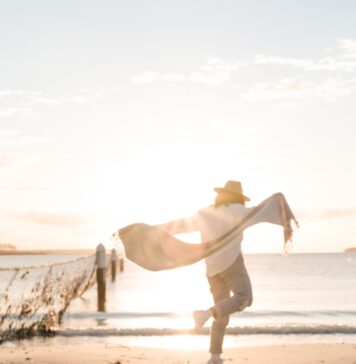 A alegria de Deus person in white sport shirt on shore during golden hour