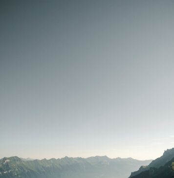 Deus está no comando da sua jornada person hiking above mountain overlooking river