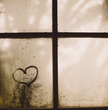 Aperfeiçoado black framed glass window with heart draw