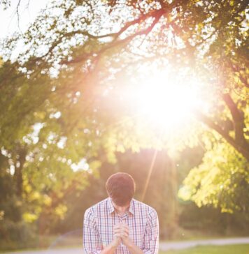 Para sua glória photo of man kneeling on grass near tree