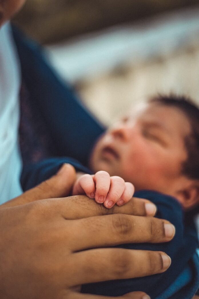 Photo by BenMoses M a man holding a baby in his arms