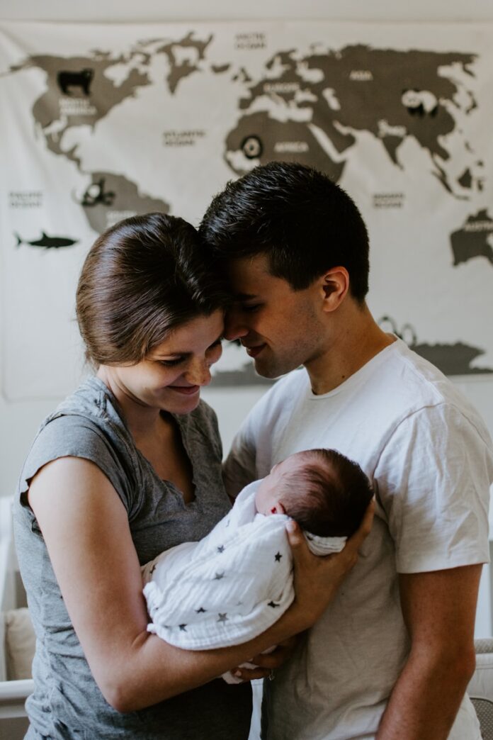 Photo by Kelly Sikkema a man and woman holding a baby in their arms