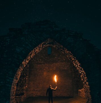 Ele está escrevendo sua história person holding torch in building interior