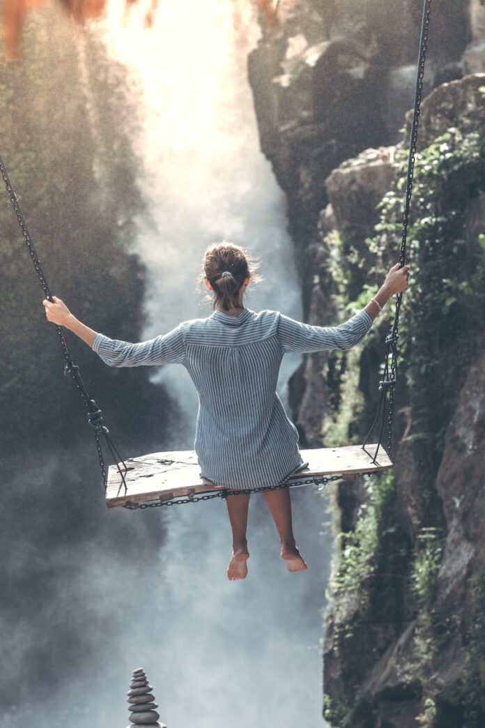Photo by Artem Beliaikin woman riding on wooden swing
