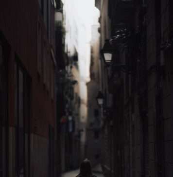 Herdeiros com Cristo a person walking down a narrow alley way