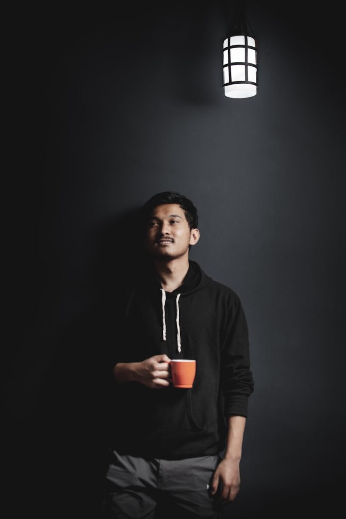 Photo by Santosh 313 man in black hoodie holding red cup