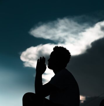 As orações que ele responde silhouette of man sitting on rock during daytime