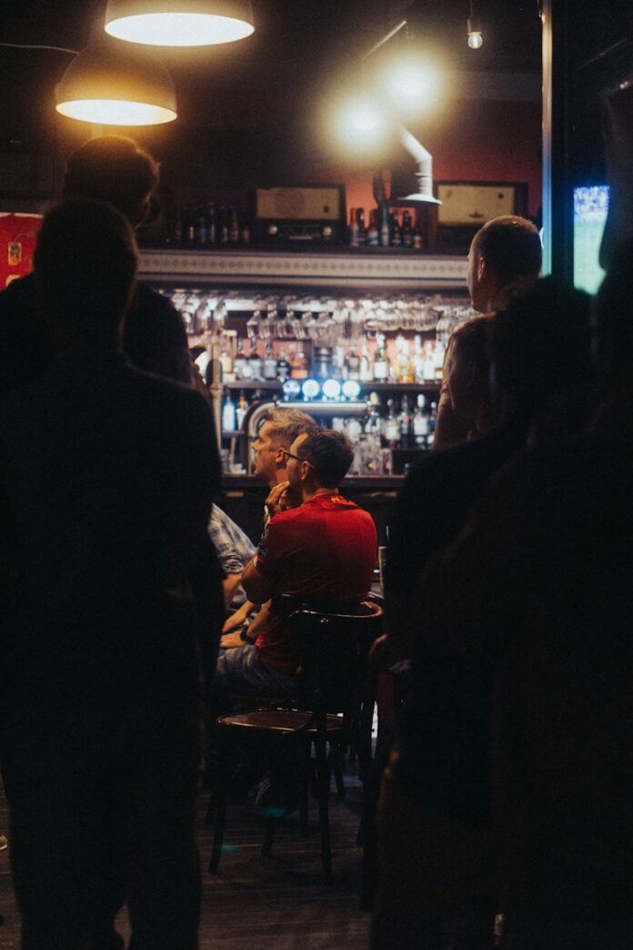 Photo by Matei Pruteanu a group of people standing around a bar
