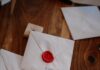 Convite de Deus White envelopes with red wax seals on wooden table