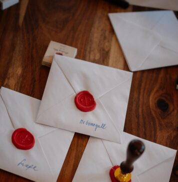 Convite de Deus White envelopes with red wax seals on wooden table