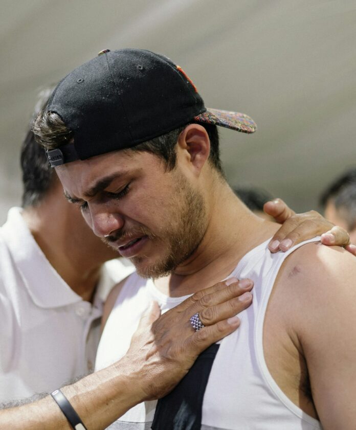 Photo by Amistad Cristiana a man holding his arm around another man's shoulder