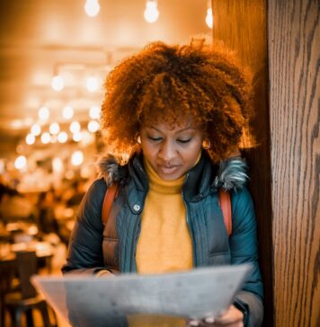 A escolha é nossa woman in brown leather jacket standing beside brown wooden wall