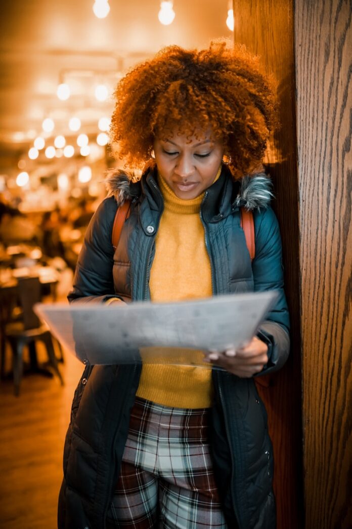 woman in brown leather jacket standing beside brown wooden wall