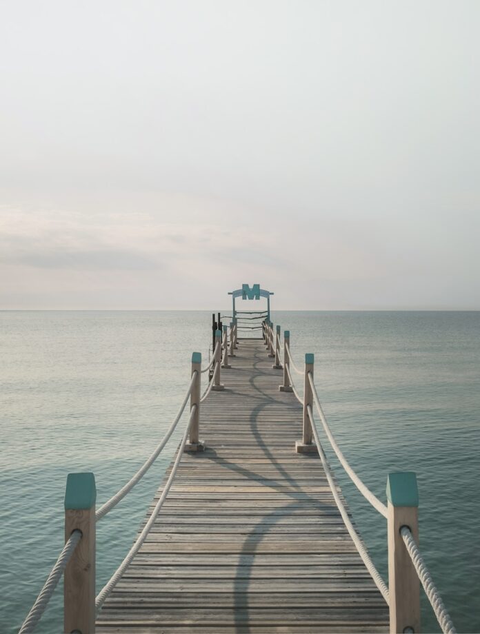 Photo by Fabrice Villard brown wooden pier near body of calm water