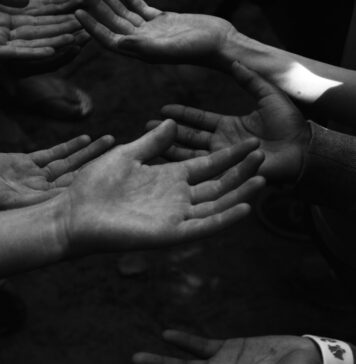Jesus é digno da nossa confiança a group of people holding their hands together