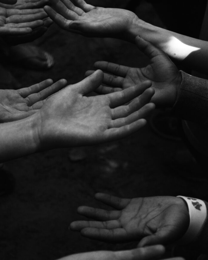 Photo by McKenna Phillips a group of people holding their hands together