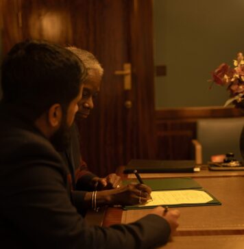 Jesus, seu advogado justo Two people are signing a document at a desk
