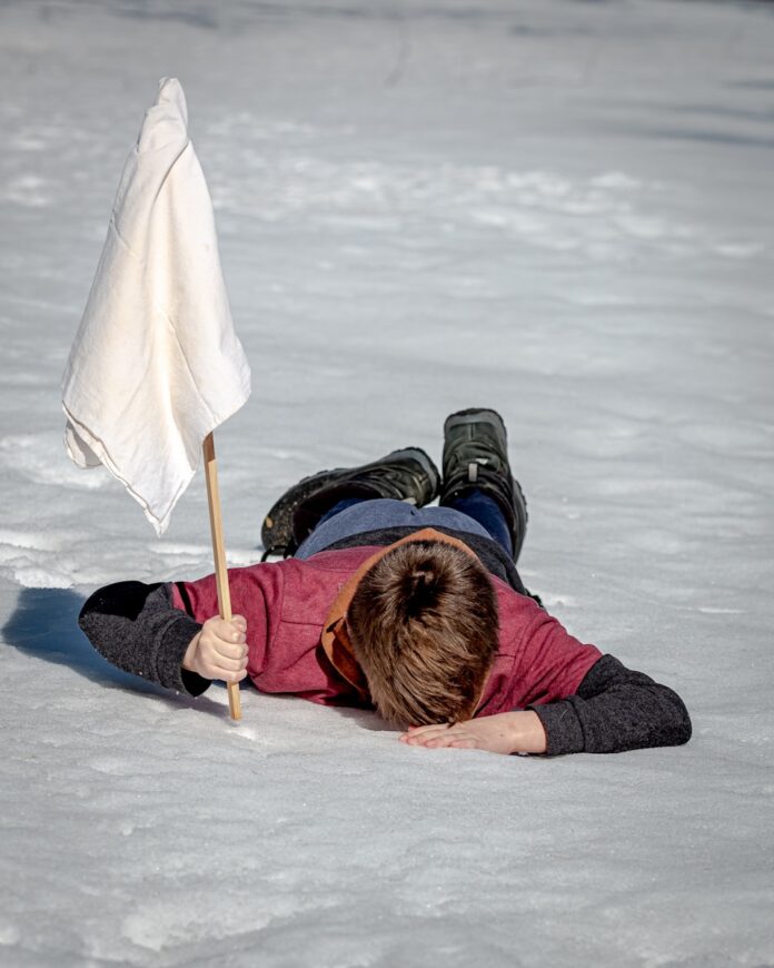 Photo by Jackson Simmer woman in black jacket lying on white snow