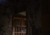 O que acabou de acontecer? an open door in a dark room with a window