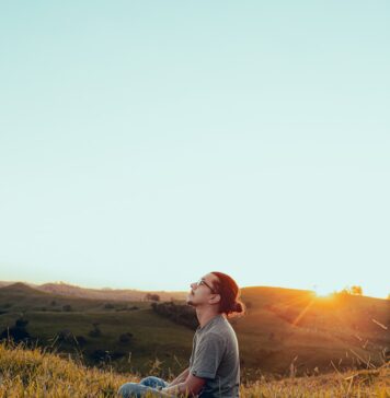 Ocupado por Cristo man in white shirt sitting on green grass field during sunset