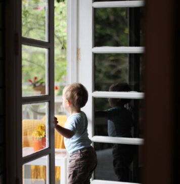 Seu Pai está vindo toddler standing beside door