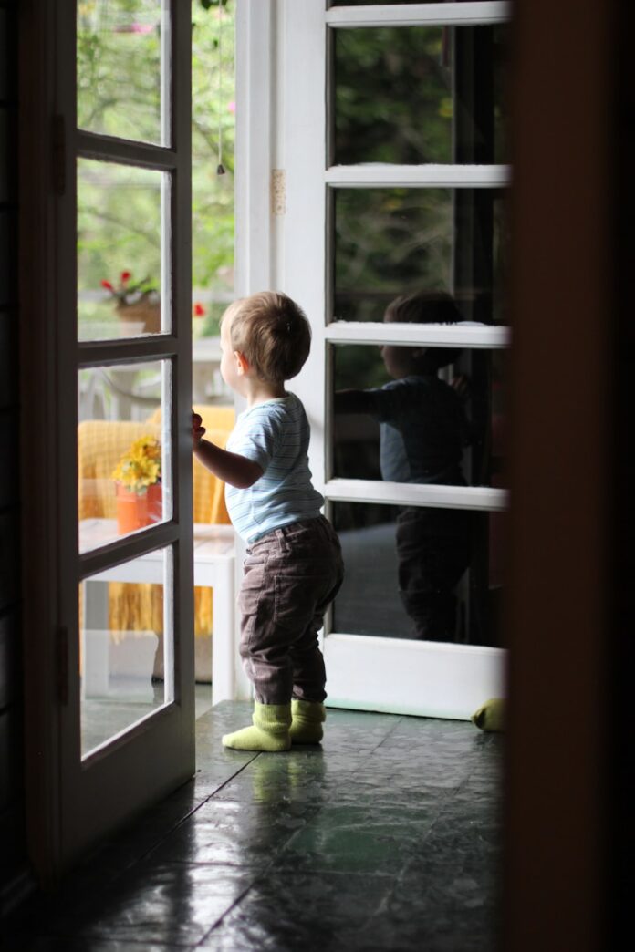 Photo by Nikoline Arns toddler standing beside door
