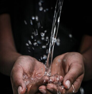 Venha e beba pouring water on person's hands