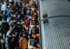 Basta desse frenesi! a crowd of people standing next to a train