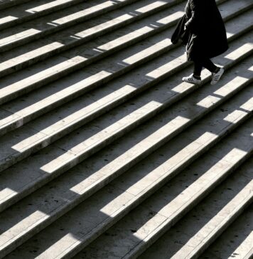 Um passo de cada vez person wearing black jacket walking on stair photography