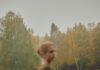 Confissão oferece liberdade A person in a brown sweater standing in a misty autumn forest clearing